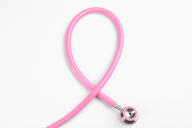 Photo of Pink stethoscope isolated on white, top view. Breast cancer awareness