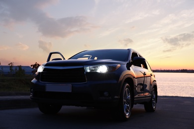 Photo of Modern new car on road near river