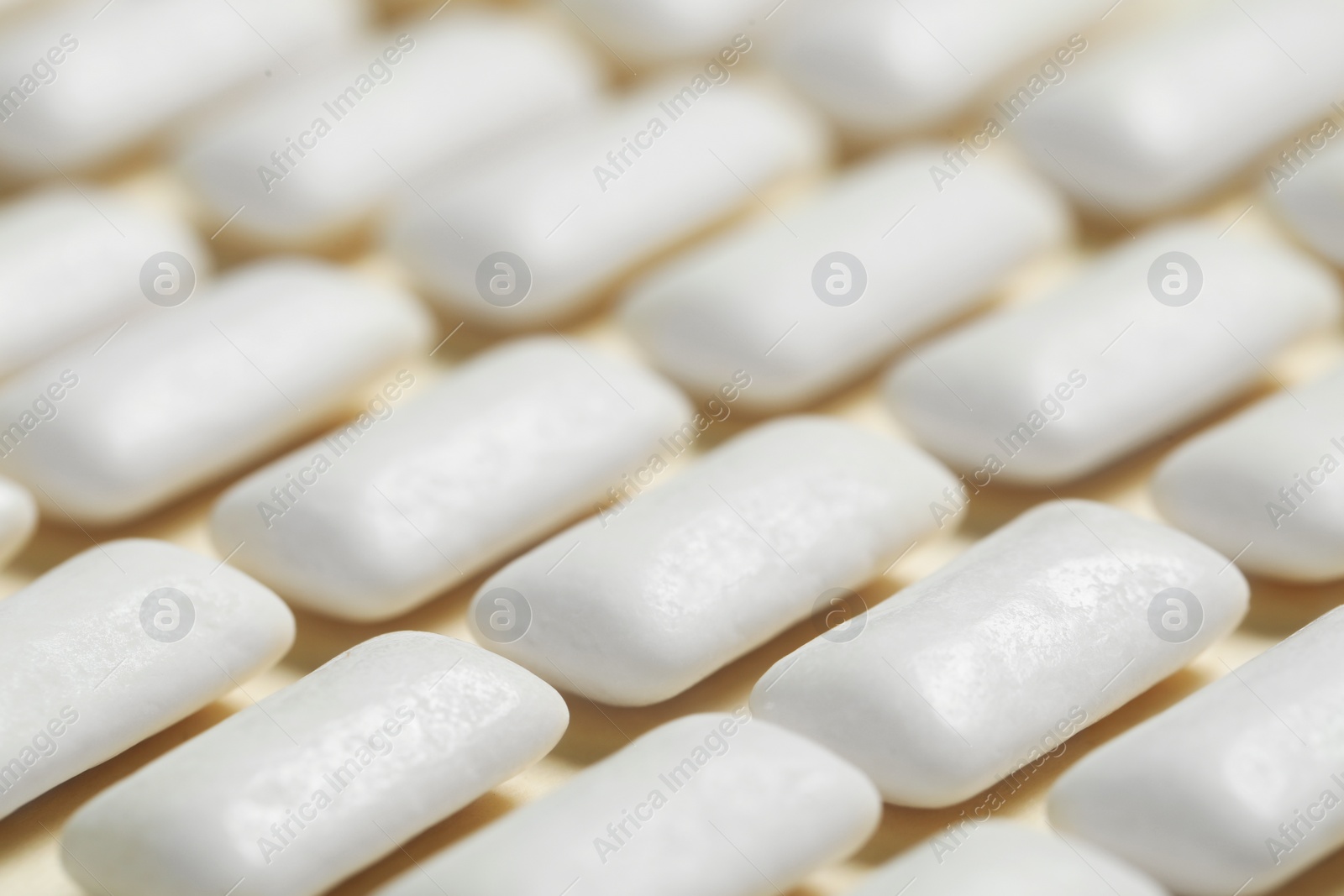 Photo of Tasty white chewing gums on beige background, closeup