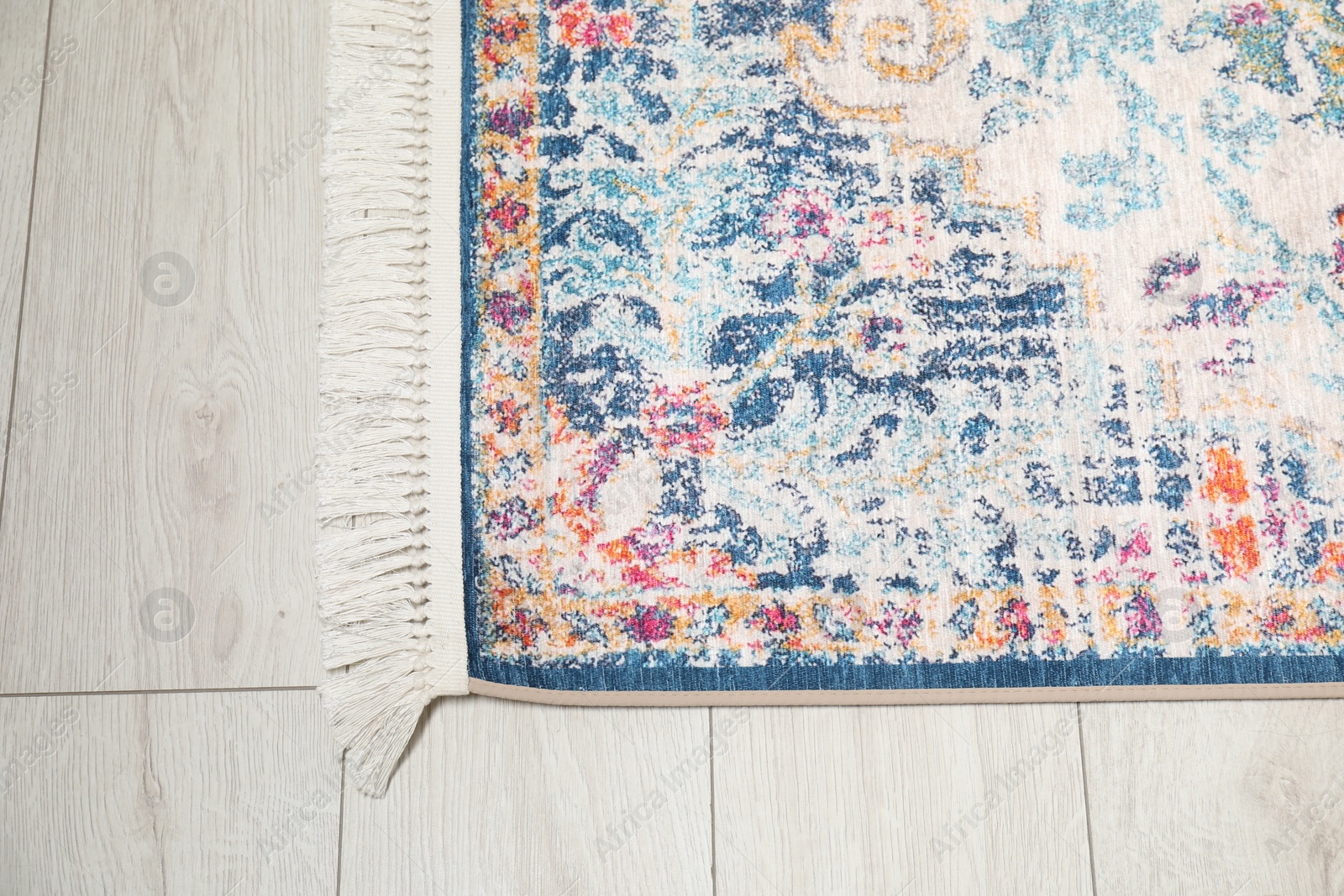 Photo of Soft carpet with pattern on white laminated floor indoors, top view