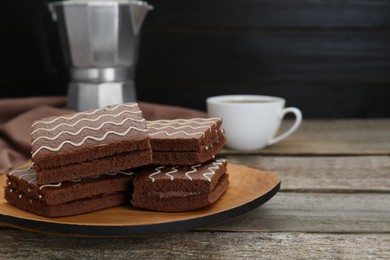 Tasty chocolate sponge cakes and hot drink on wooden table, closeup. Space for text