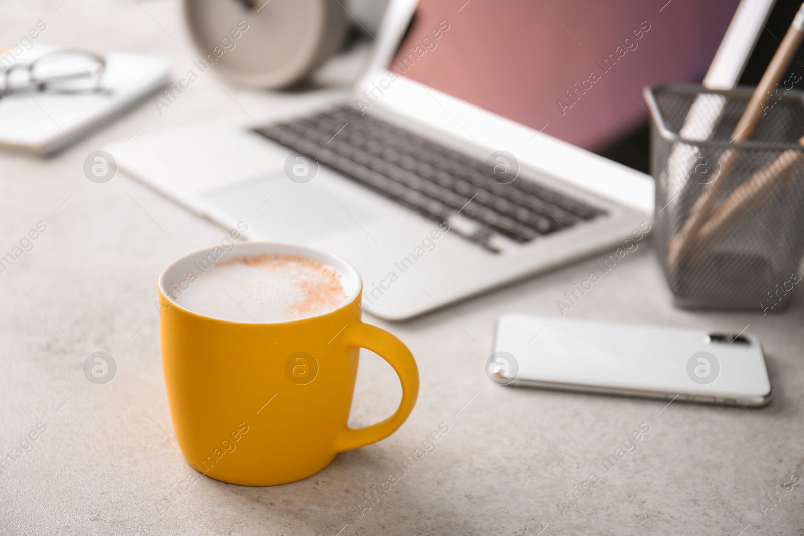 Photo of Yellow cup with coffee on office table. Space for text