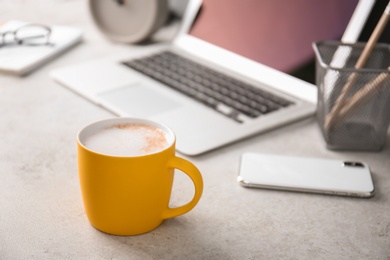 Photo of Yellow cup with coffee on office table. Space for text