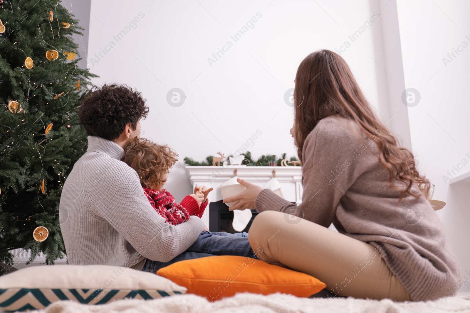 Photo of Family watching movie via video projector at home, back view