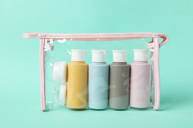 Cosmetic travel kit in plastic bag on turquoise background. Bath accessories