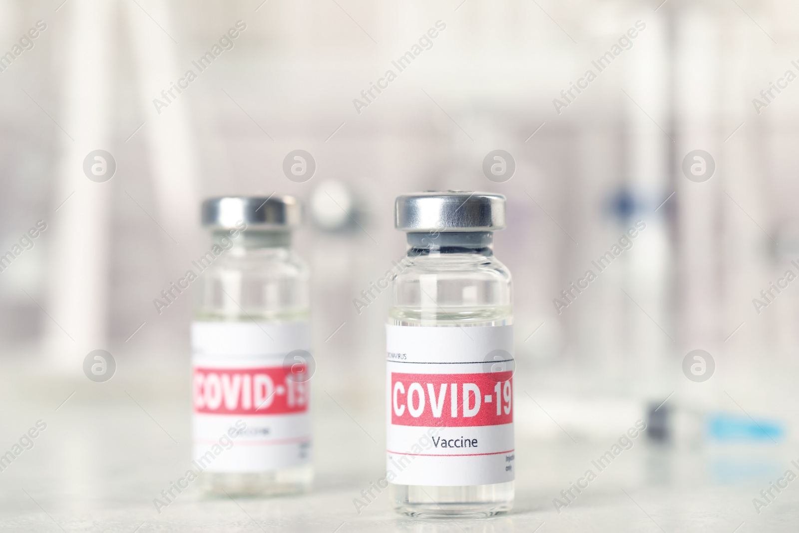 Photo of Vials and syringe with coronavirus vaccine on light table