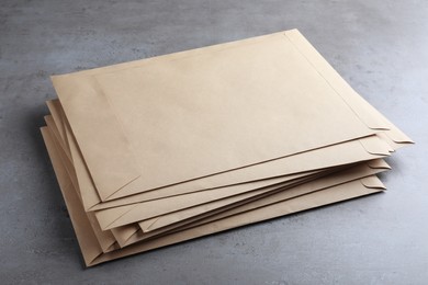 Stack of kraft paper envelopes on grey table