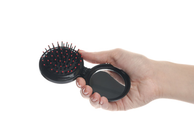 Photo of Woman holding round folding hair brush with mirror on white background, closeup