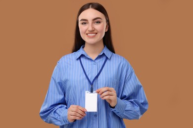 Happy woman with blank badge on brown background