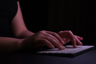 Photo of Woman using computer in dark room, closeup. Internet addiction