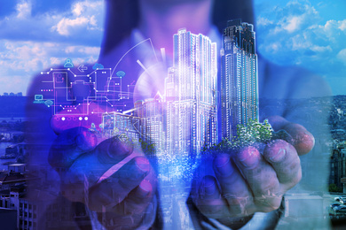 Image of Young woman holding virtual image of buildings, closeup. Modern technology