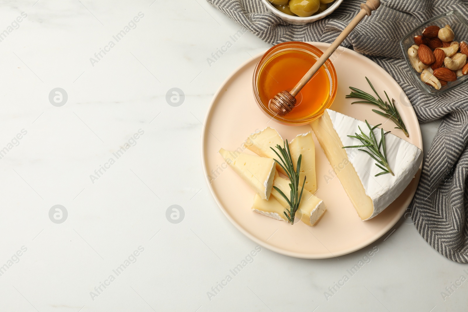 Photo of Tasty Camembert cheese with rosemary and honey on white table, flat lay. Space for text