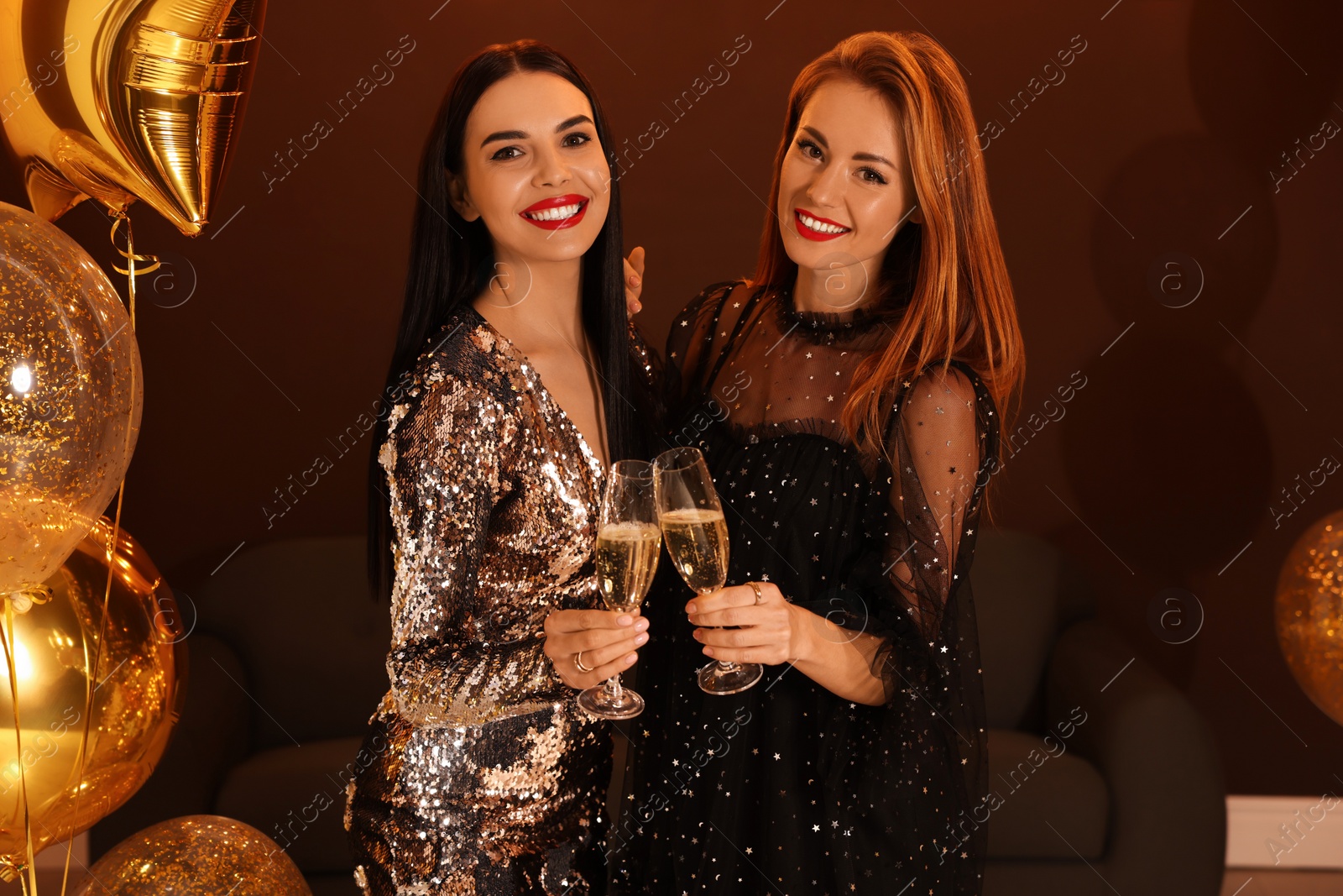 Photo of Happy women with glasses of sparkling wine celebrating New Year indoors