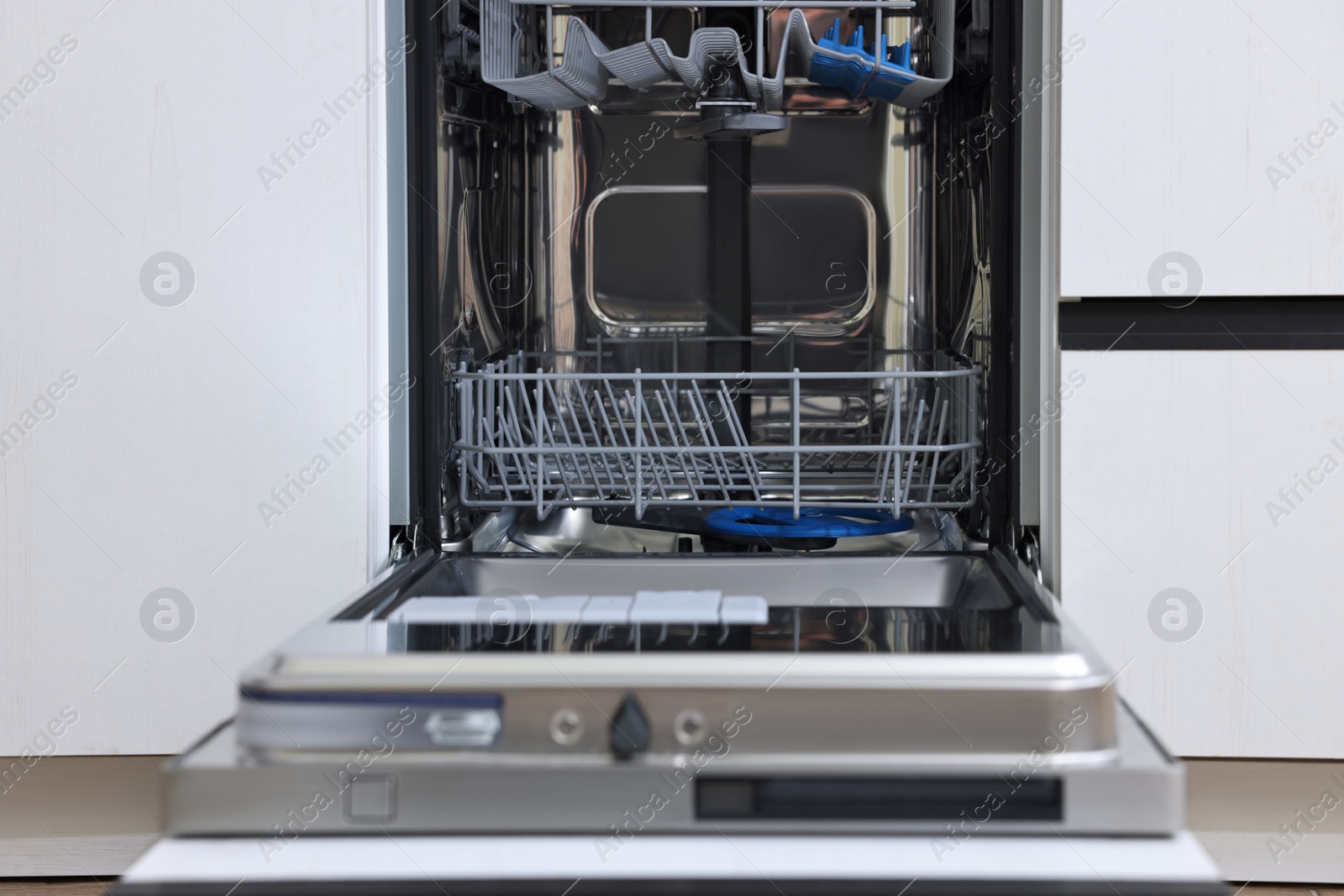 Photo of Open clean empty dishwasher in kitchen. Home appliance