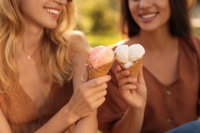 Young women with ice cream spending time together outdoors, closeup