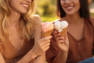 Photo of Young women with ice cream spending time together outdoors, closeup