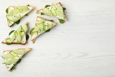 Photo of Flat lay composition with traditional English cucumber sandwiches on white wooden background. Space for text