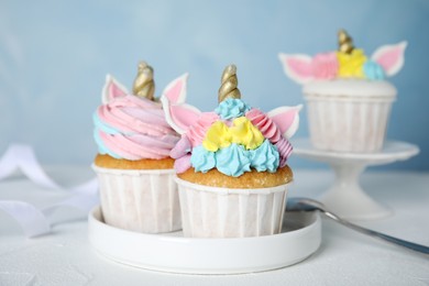 Cute sweet unicorn cupcakes on white table