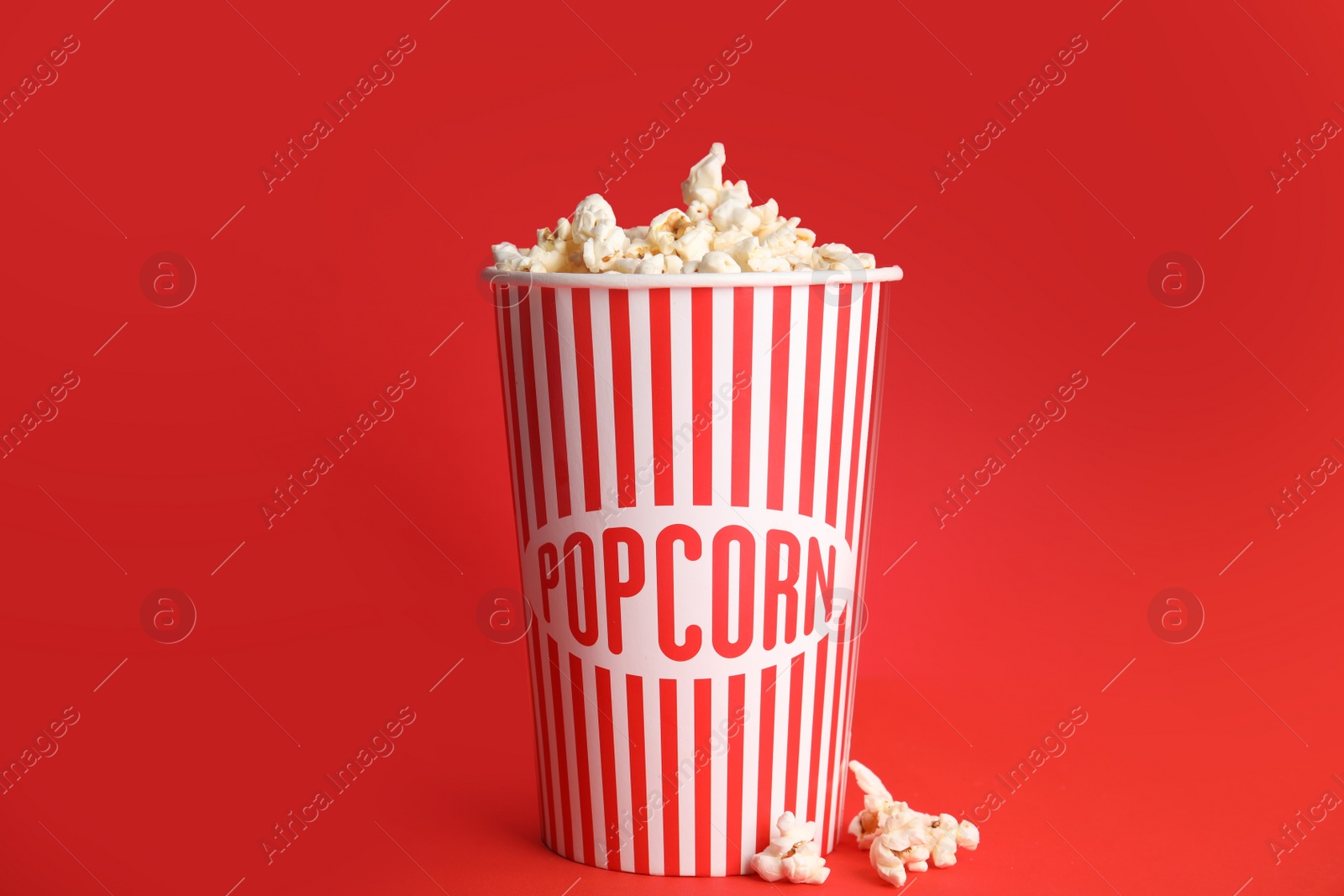 Photo of Tasty fresh pop corn on red background