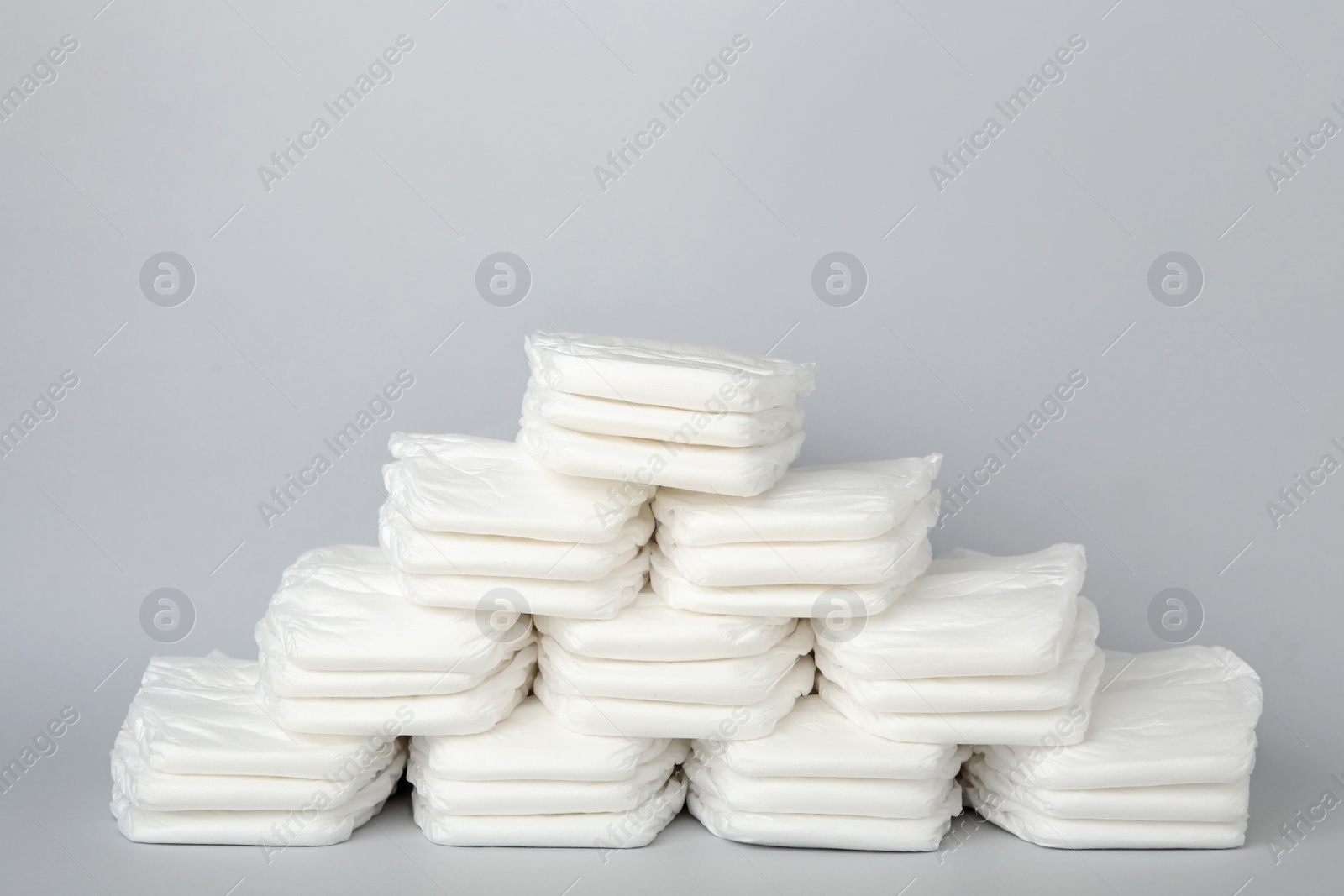 Photo of Pile of baby diapers on light grey background