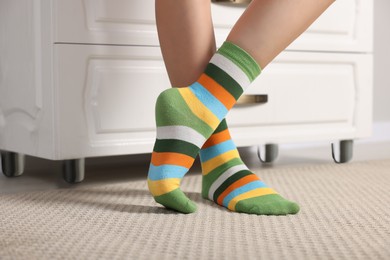 Photo of Woman in stylish colorful socks indoors, closeup