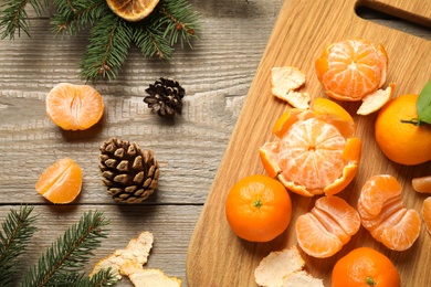 Photo of Flat lay Christmas composition with fresh tangerines and fir tree branches on wooden table