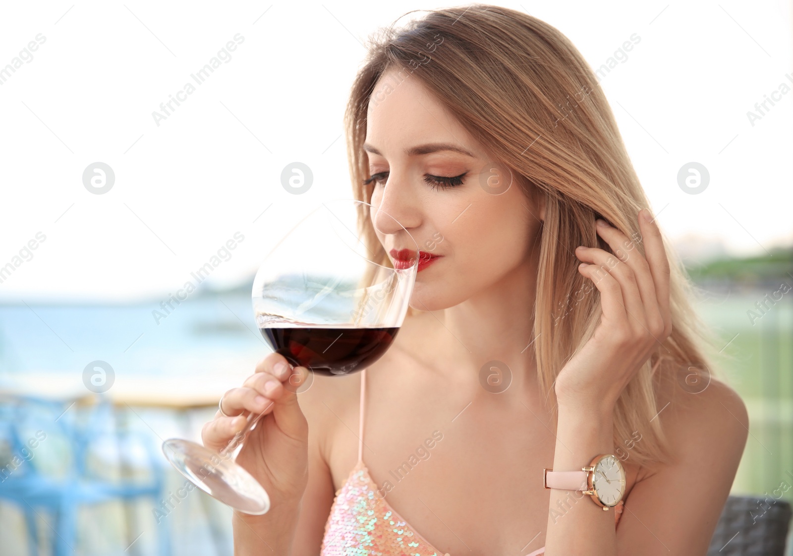 Photo of Young woman with glass of red wine outdoors