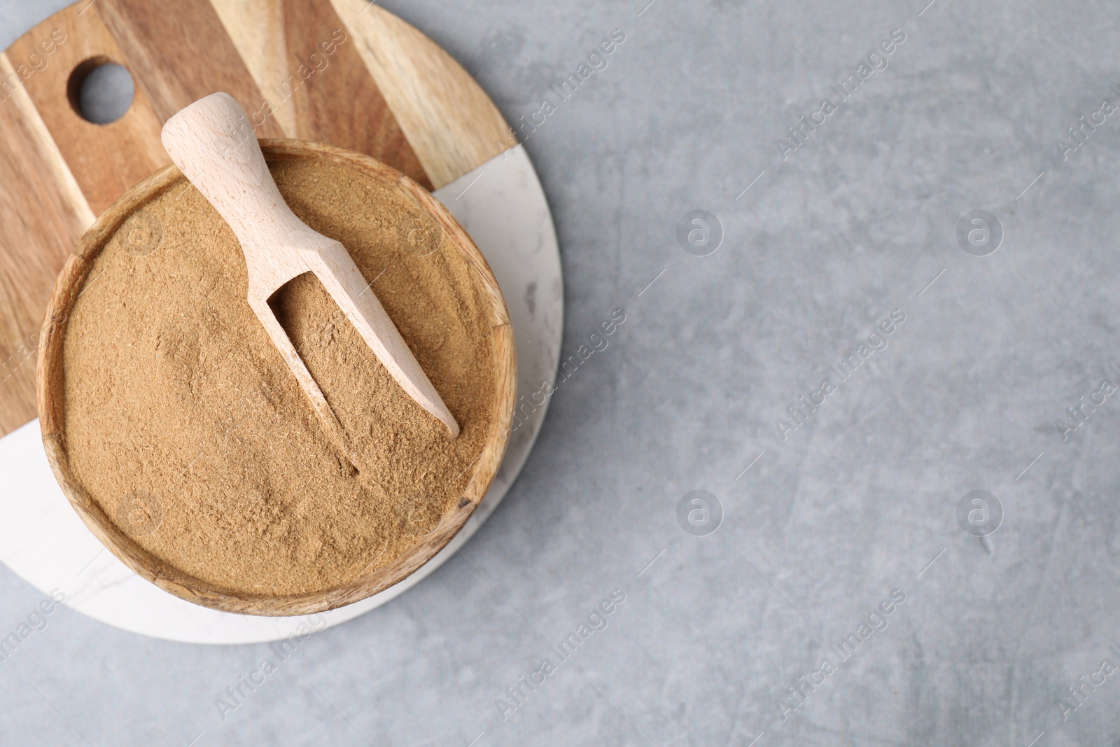 Photo of Dietary fiber. Psyllium husk powder in bowl and scoop on grey table, top view. Space for text