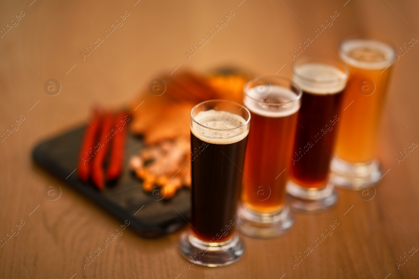 Photo of Beer tasting set served with snacks on wooden table