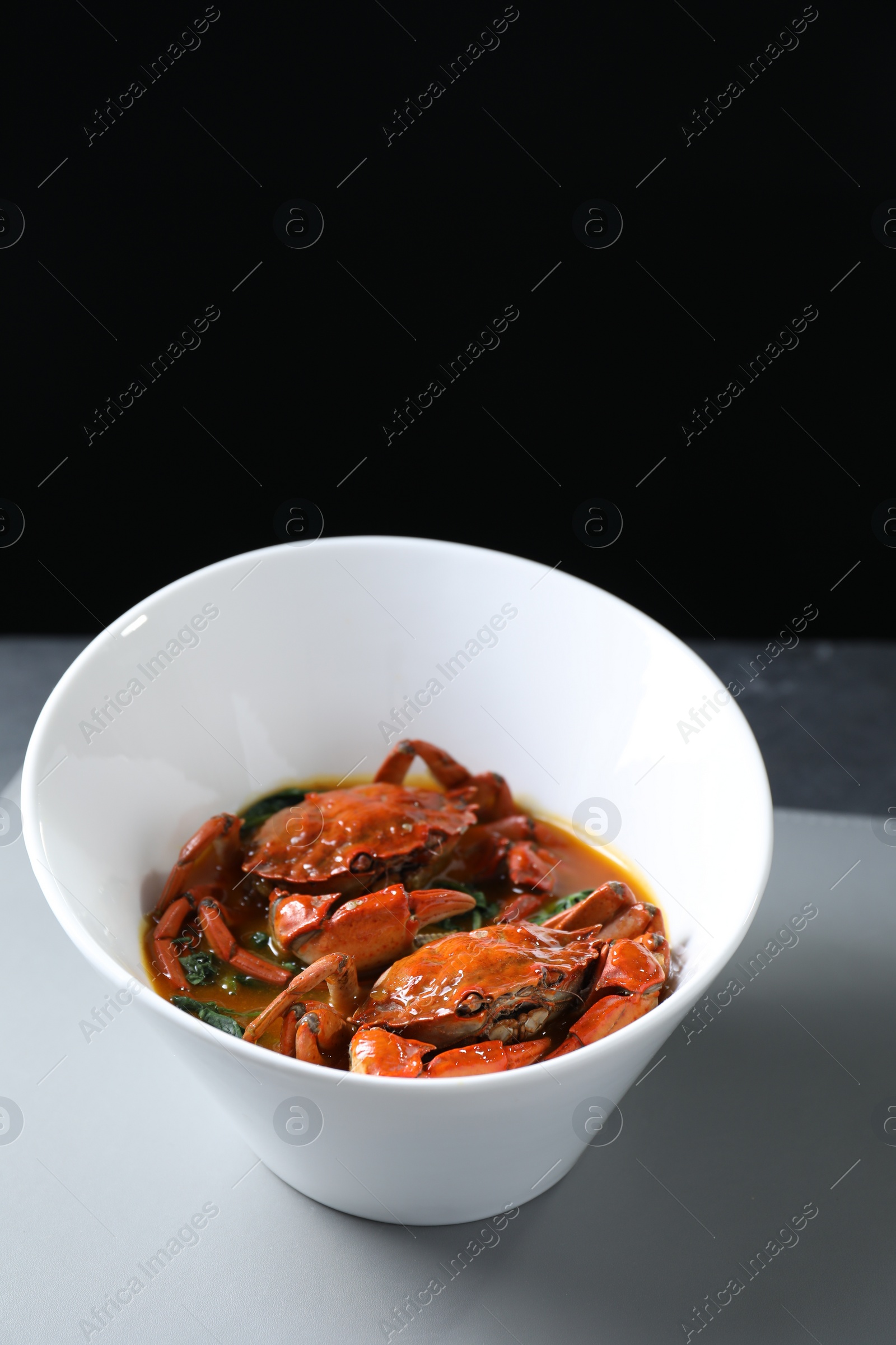 Photo of Delicious boiled crabs with sauce on table, space for text