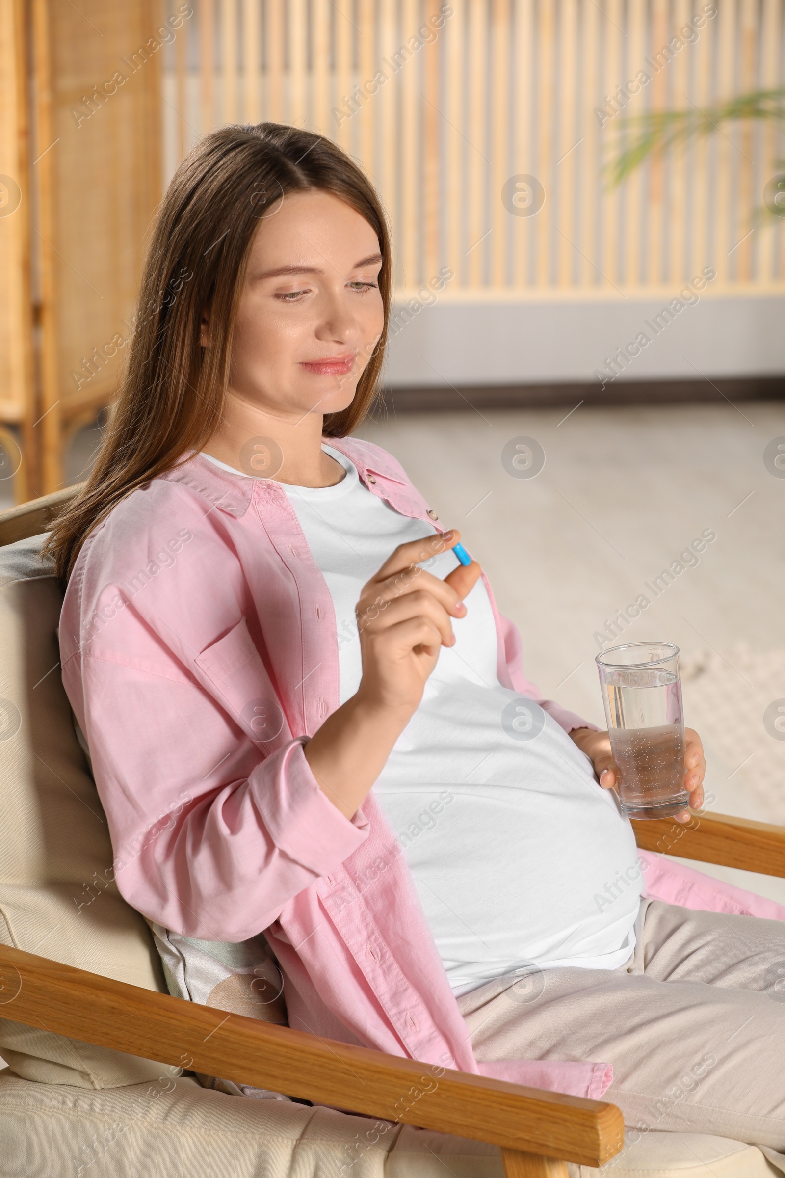 Photo of Beautiful pregnant woman taking pill at home