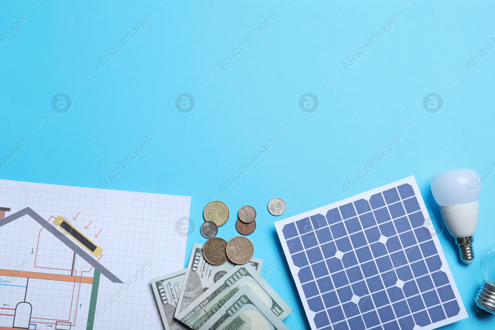 Photo of Flat lay composition with solar panel and money on light blue background. Space for text