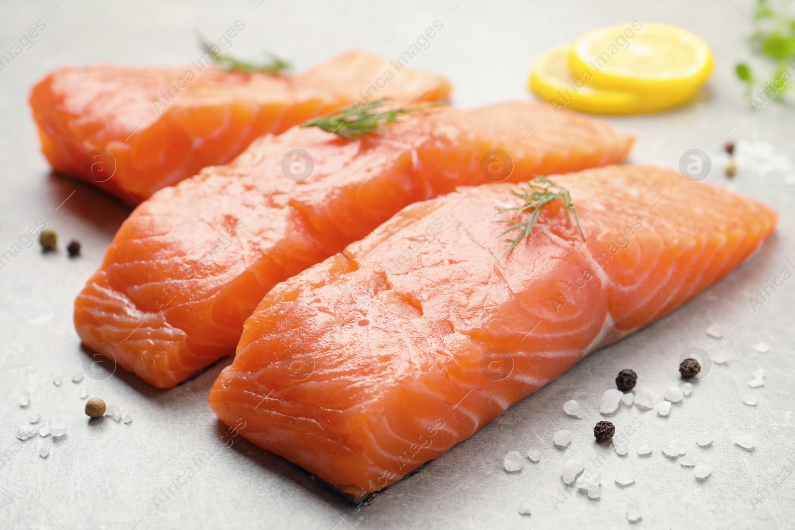 Photo of Fresh raw salmon and ingredients for marinade on light grey table, closeup