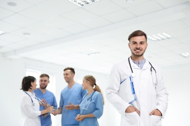 Portrait of male doctor and his colleagues at workplace