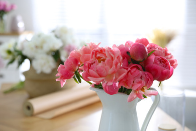 Photo of Beautiful bouquet of fragrant peonies in vase on table, closeup