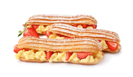 Photo of Delicious eclairs filled with cream and strawberries isolated on white