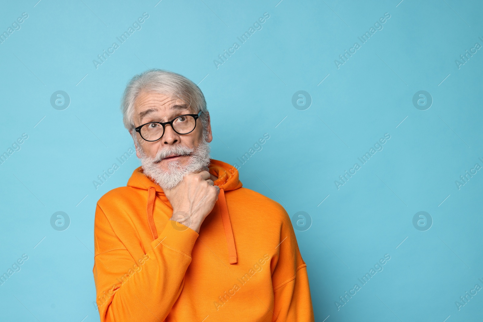 Photo of Senior man with mustache on light blue background, space for text