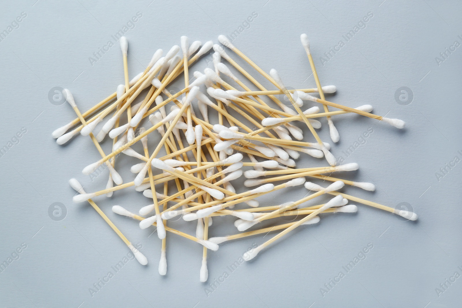 Photo of Heap of wooden cotton buds on light grey background, flat lay