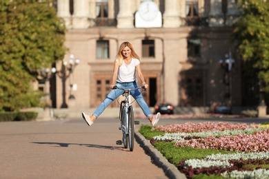 Happy woman riding bicycle outdoors on sunny day