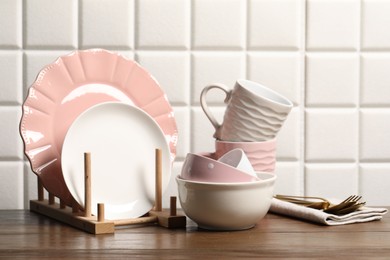 Beautiful ceramic dishware, cups and cutlery on wooden table