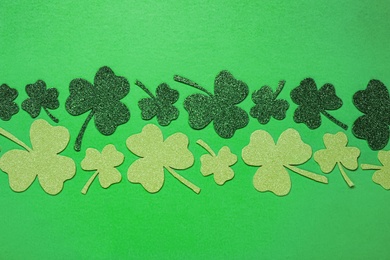 Photo of Flat lay composition with clover leaves on light green background. St. Patrick's Day celebration