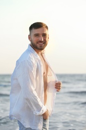 Photo of Young man enjoying sunny day on beach