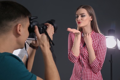 Beautiful young model posing for professional photographer in studio