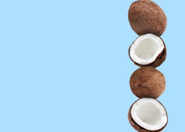 Stack of fresh coconuts on pale light blue background. Space for text