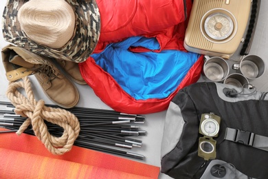 Photo of Flat lay composition with sleeping bag and camping equipment on grey background
