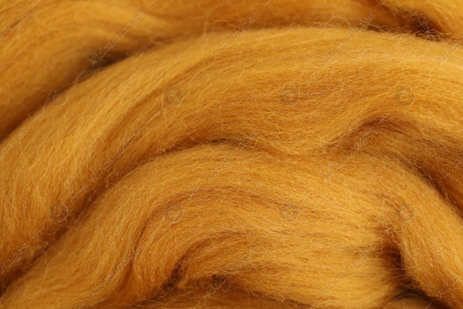 Photo of Orange felting wool as background, closeup view