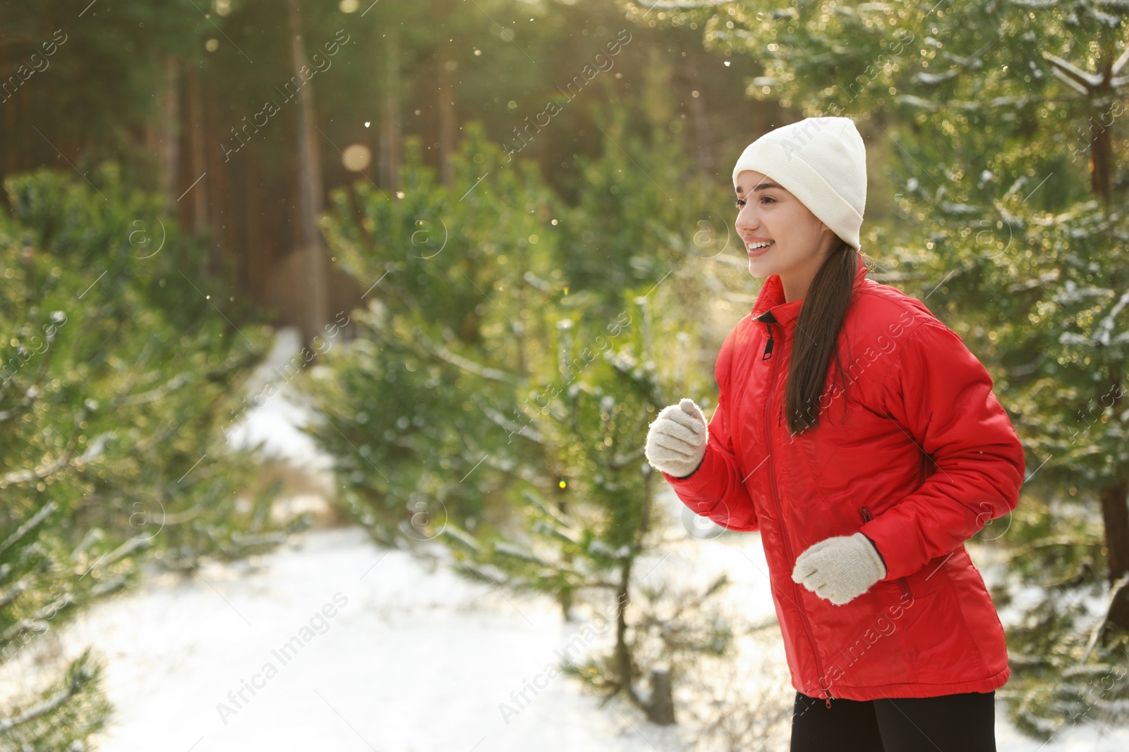Photo of Happy woman running in winter forest. Outdoors sports exercises