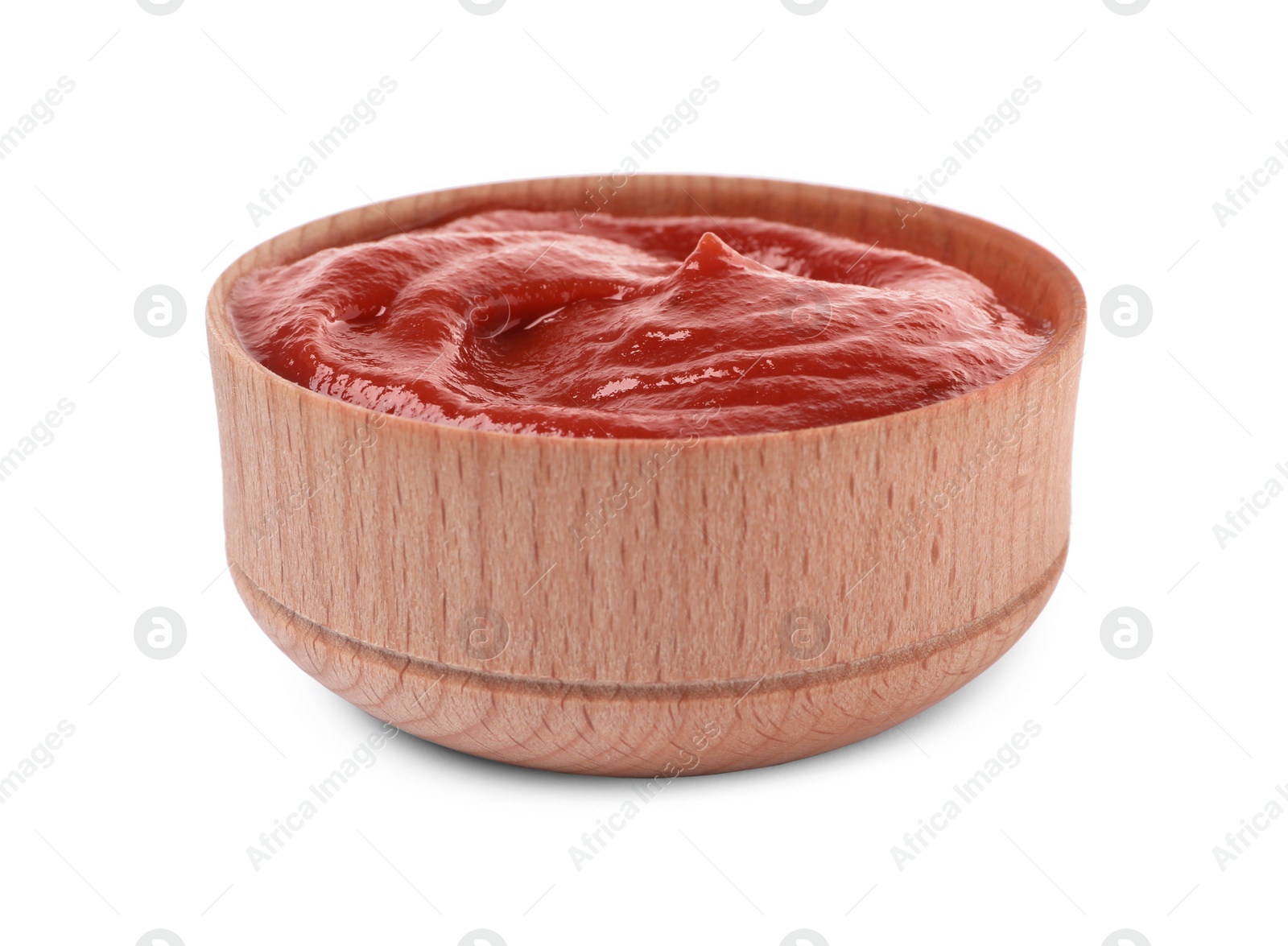 Photo of Tasty ketchup in wooden bowl isolated on white