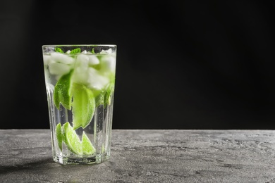 Photo of Refreshing beverage with mint and lime in glass on table