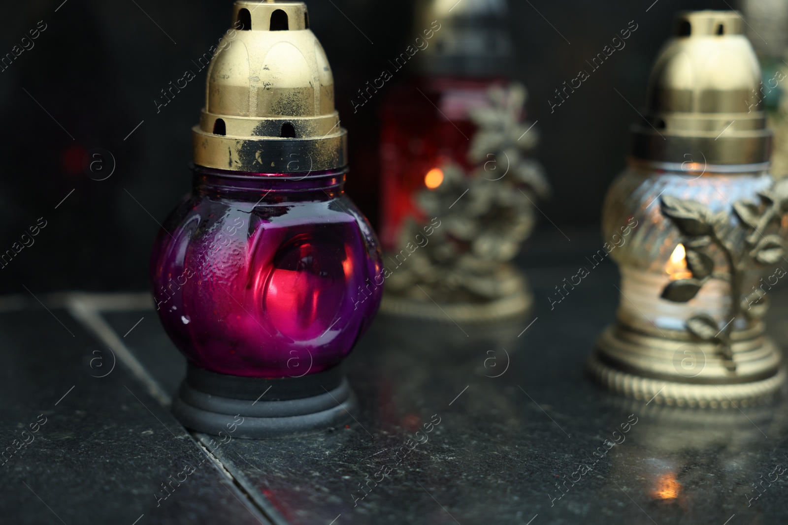 Photo of Grave lights on granite surface at cemetery, closeup